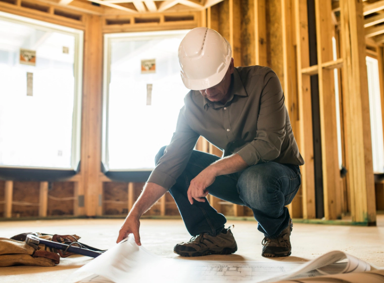 contractor checking plans of a house